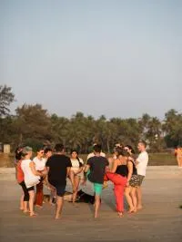 A group of people on a beach practicing yoga or a similar movement exercise