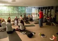 A group of people sitting on yoga mats with an instructor in a studio.