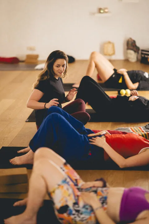 Instructor guiding students during a restorative breathwork and relaxation class.