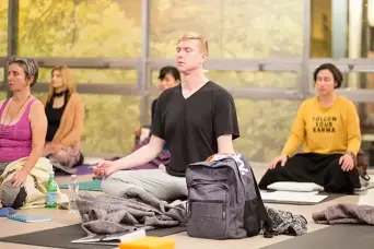 A group of people meditating in a class.