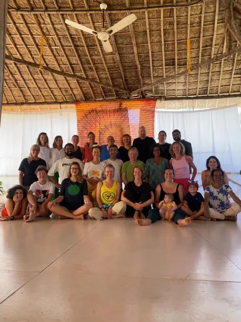Yoga retreat group posing together inside an open-air shala